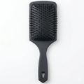 Professional black paddle brush product image for barber and salon styling.