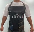 Person wearing a black barber apron with 'BARBER' printed on it against a light background