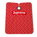 Professional red barber cape with white monogram-style print and black gathered neckline